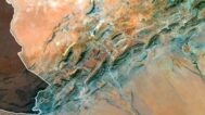 Satellite view of Algeria highlighting the Sahara desert and mountainous regions.